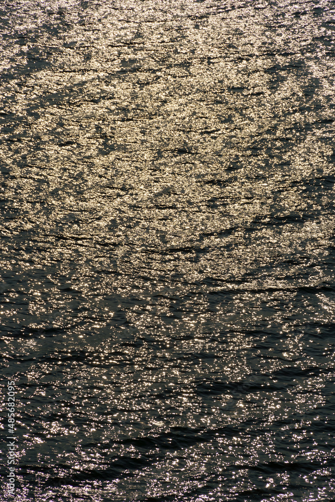 golden sunlight reflected in a waves at sunset, dark contrast background seascape, top view, beautiful sea