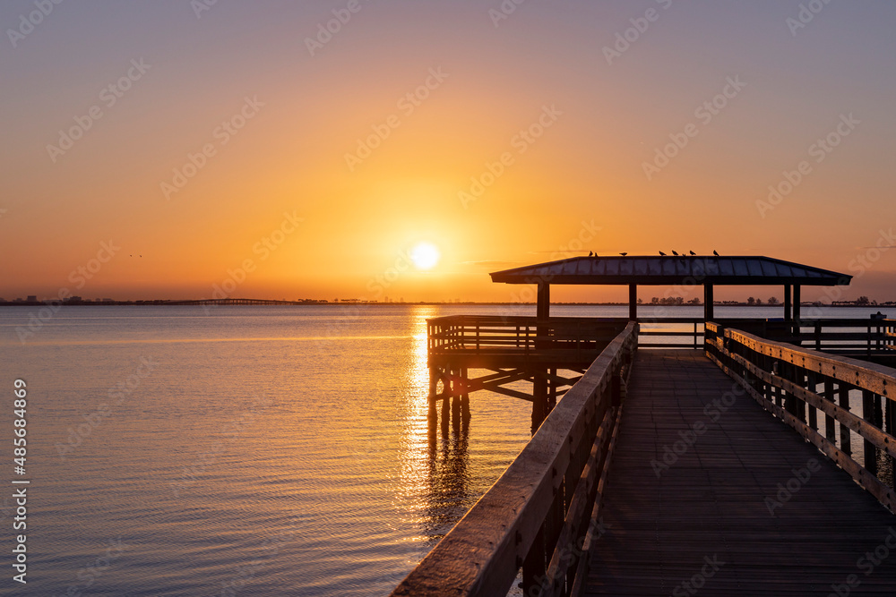 Sunrise over the pier in Safety Harbor, Florida reflecting in Tampa Bay.
