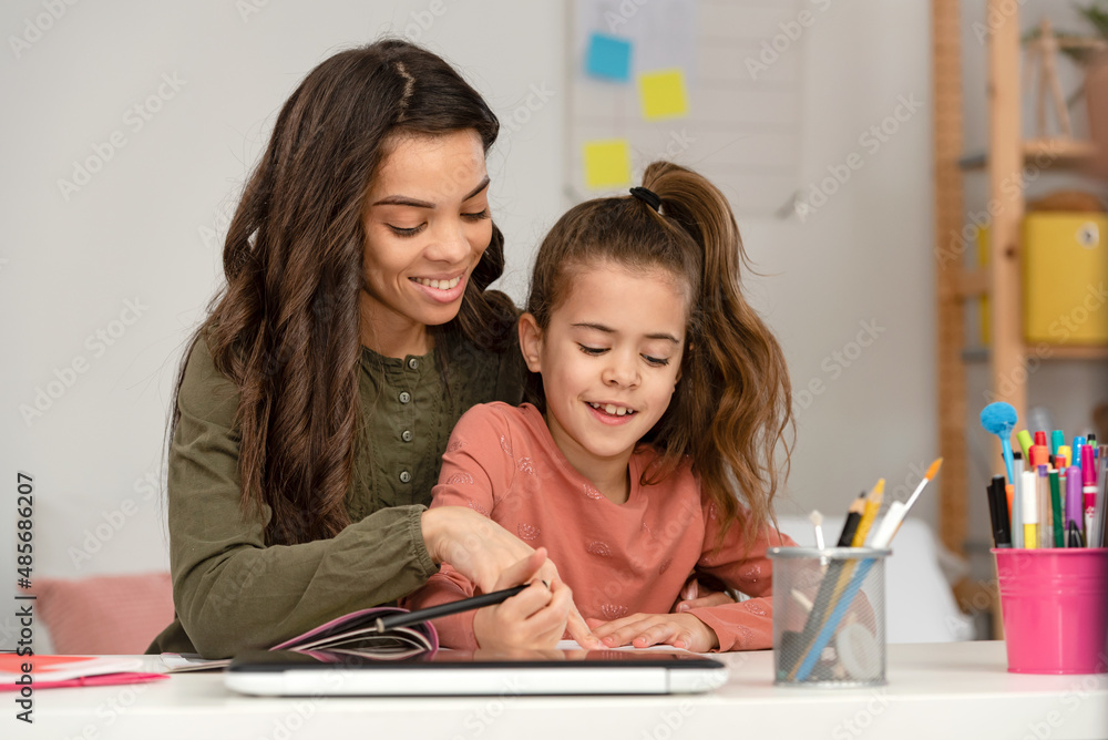 Mother helping a child to do homework. Home education concept. Mother and daughter bonding. Mother helping a child to do homework. Home education concept. Mother and daughter bonding.