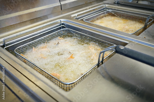 Deep fryers with boiling oil on fast food kitchen