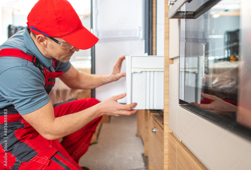 RV Technician Worker Repairing Motorhome Refrigerator RV Technician Worker Repairing Motorhome Refrigerator