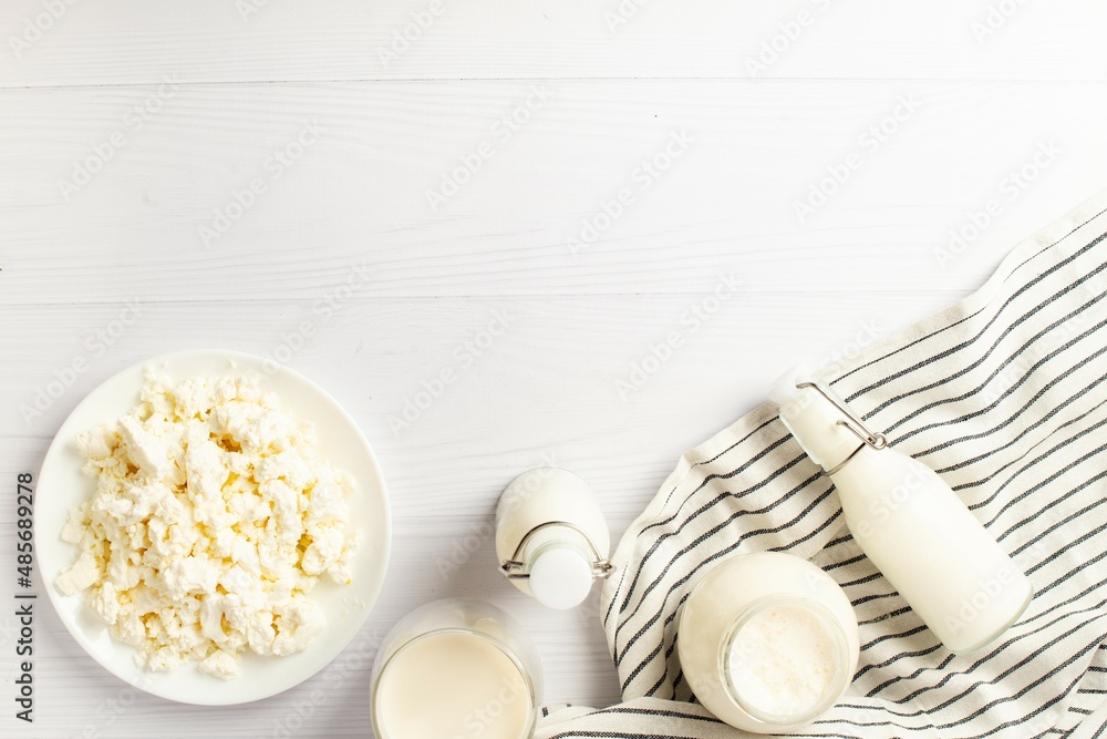 Fototapeta premium Fresh dairy products, wheat, white wood background, top view