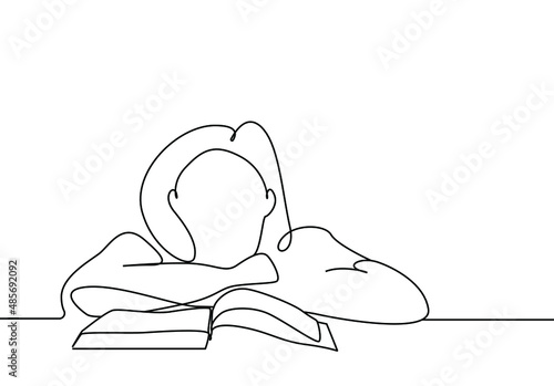 girl with her head on the table in front of the book thinks