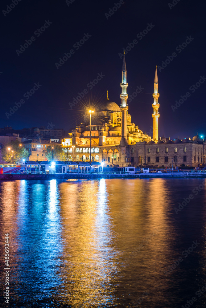 Obraz premium Reflection of New Mosque (New Valide Sultan Mosque) in the Golden Horn at night, Istanbul, Turkey, Eastern Europe