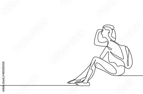 A woman with a backpack looks away and brings her hands to her eyes