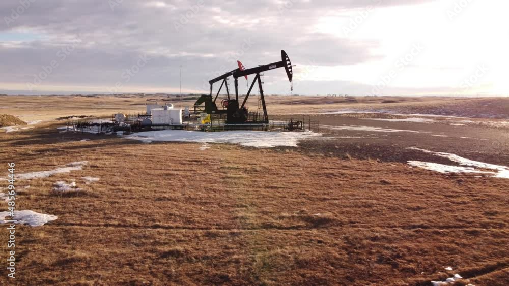 Cremona Alberta Canada, January 22 2022: Aerial flight near a working pump jacks oil field on the Canadian Prairies. Cremona Alberta Canada, January 22 2022: Aerial flight near a working pump jacks oil field on the Canadian Prairies.