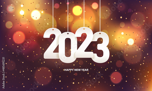Happy new year 2023. Hanging white paper number with confetti on a colorful blurry background.