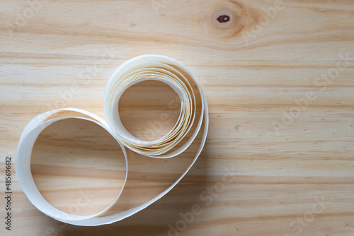 white paper ribbon coil on a wooden surface