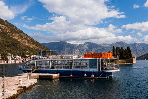 Perast, Montenegro - 15.09.2021: Tourists sailed on a yacht to the island of gospa od skrpela in the boka bay of kotor. Roman catholic church our lady of the rocks on island islet photo