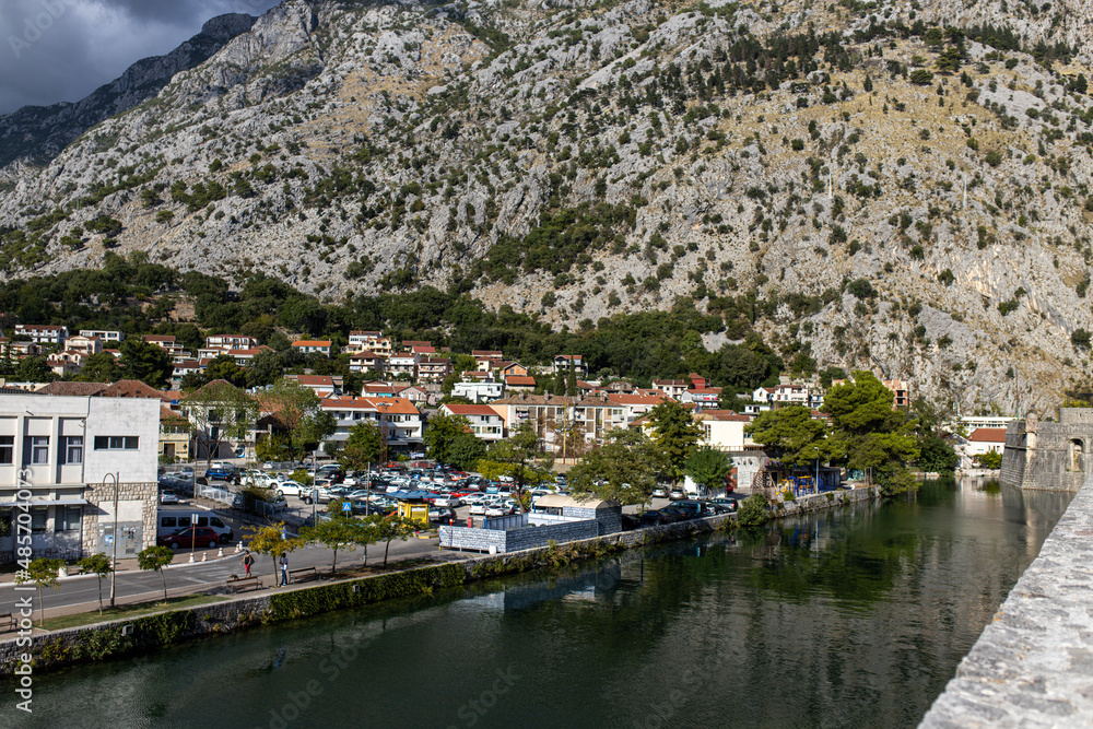 Summer view of Kotor old wall Fortification in Montenegro. Unesco world heritage. Europe travel site. Vacation concept.  Tourism in adriatic sea. Serbian history of balkans, fort and port buildings.