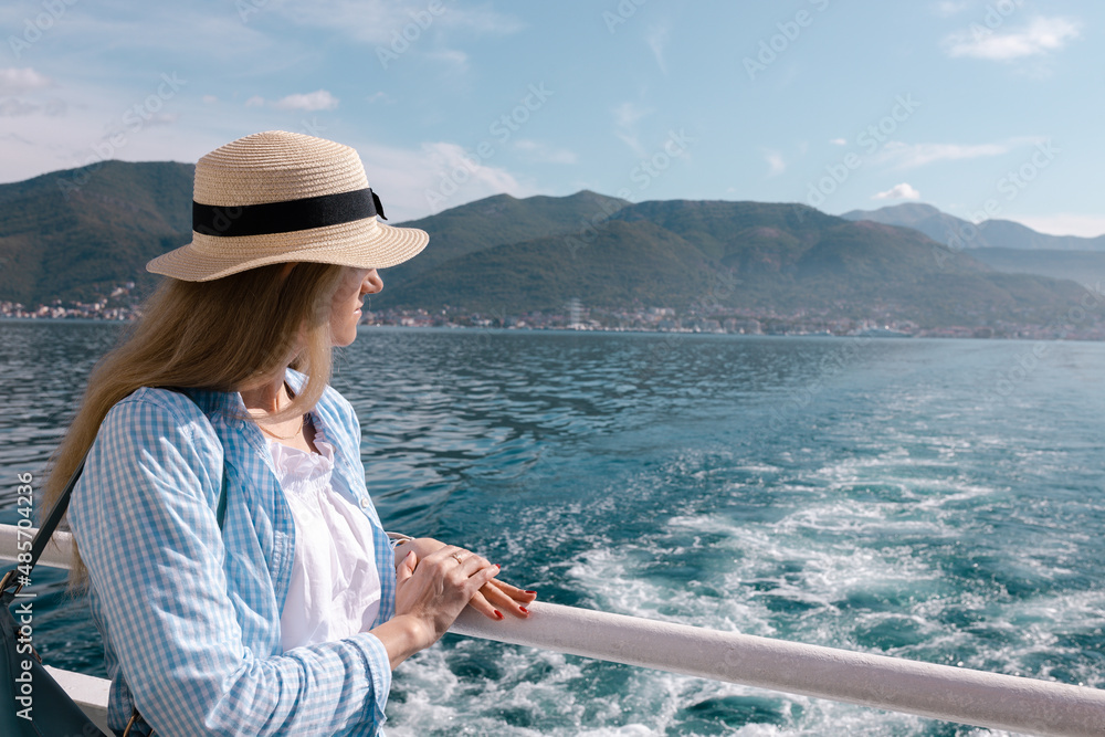 Woman in a hat haon a ship in Bay of Kotor, the Adriatic Sea in southwestern Montenegro. Its well-preserved group of medieval towns Kotor, Tivat, Perast and Herceg Novi. Travelling and leasure concept