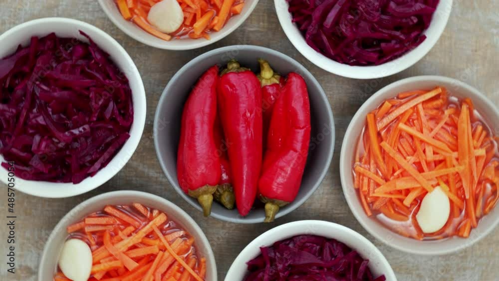 Bowls with homemade ferment food vegetable pickle: carrot, red cabbage and peppers. Top view, table spin. Bowls with homemade ferment food vegetable pickle: carrot, red cabbage and peppers. Top view, table spin.