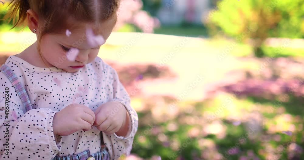 little baby girl having fun playing with flowers in spring garden little baby girl having fun playing with flowers in spring garden