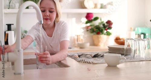 young boy pouring a tap water in glass, pure drinking water