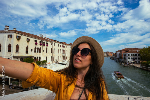 Travel influencers Venice island. Paint building house in Europe Venezia city. Photographer blogger girl with smartphone in Venice San Marco square. Traveling and freelancing, modern lifestyle. © Maksym