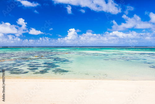 Tropical white sandy beach, perfect clear blue turquoise water and clear blue sky on a paradise island in the Pacific Ocean in Muri area of Rarotonga, Cook Islands, background with copy space