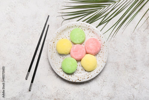 Obraz na plátne Plate with delicious mochi and chopsticks on grunge background