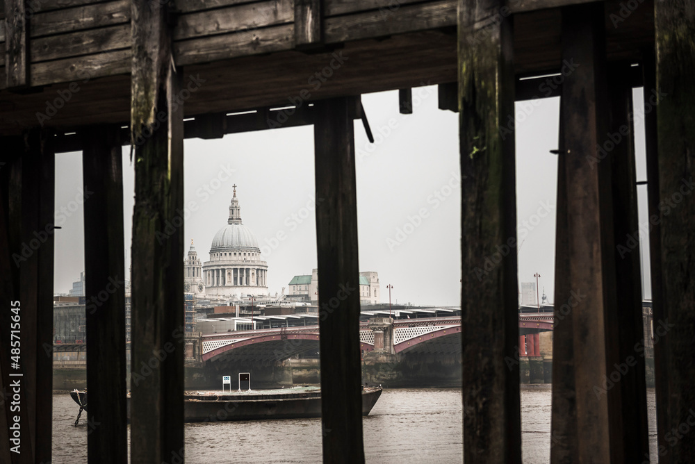 St Paul's Cathedral seen below a pier on the banks of the River Thames, South Bank, London, England
