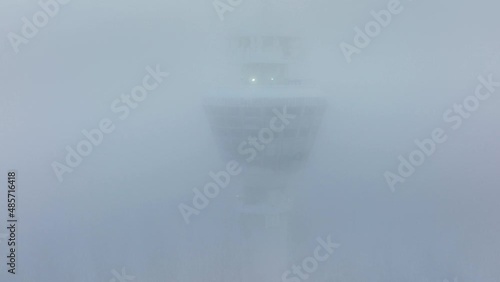 Aerial drone view revealing the Puijo tower, covered in ice fog in Kuopio, winter in Finland photo
