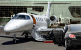 Private jet waiting for passenger with black limo in airport