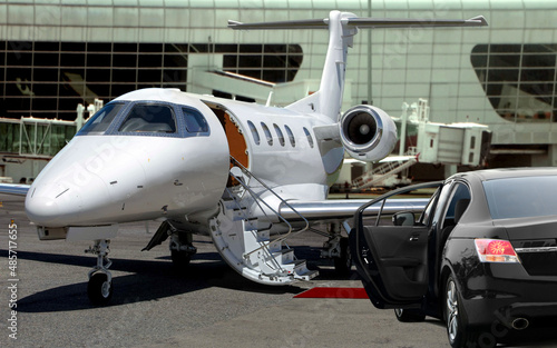Private jet waiting for passenger with black limo in airport photo