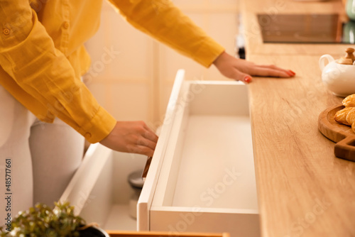 Tableau sur toile Woman opening empty kitchen drawer, closeup