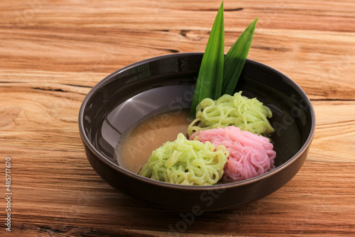 Putu Mayang or Petulo, Indonesian Traditional Javanese Snack Made of Rice Flour Strands Curled up into a Ball with Food Coloring, Served with Coconut Milk and Palm Sugar Syrup. photo