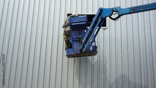 Workers are installing galvanized sheets.