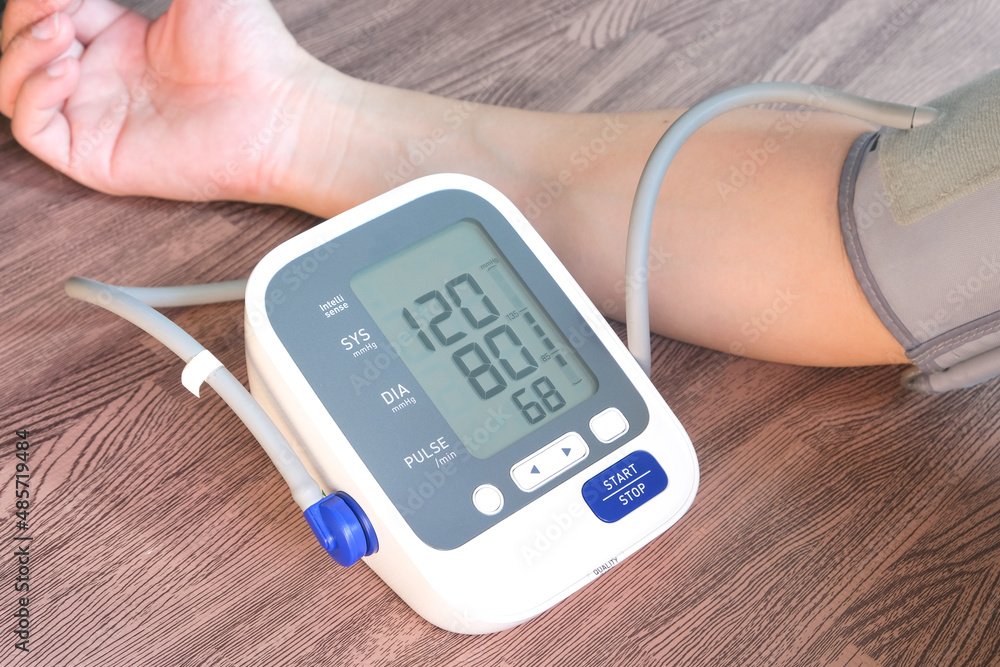 Man check blood pressure monitor and heart rate monitor with digital pressure gauge. Health care and Medical concept Man check blood pressure monitor and heart rate monitor with digital pressure gauge. Health care and Medical concept