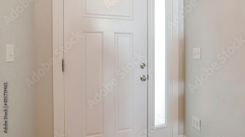 Panorama Interior of a white front door of a house with side glass panel © Jason