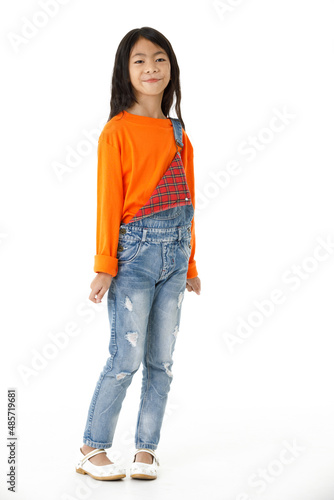 Portrait full body cutout studio shot of Asian young elementary school girl in casual party outfit with black witch hat standing smiling posing pointing finger up look at camera on white background