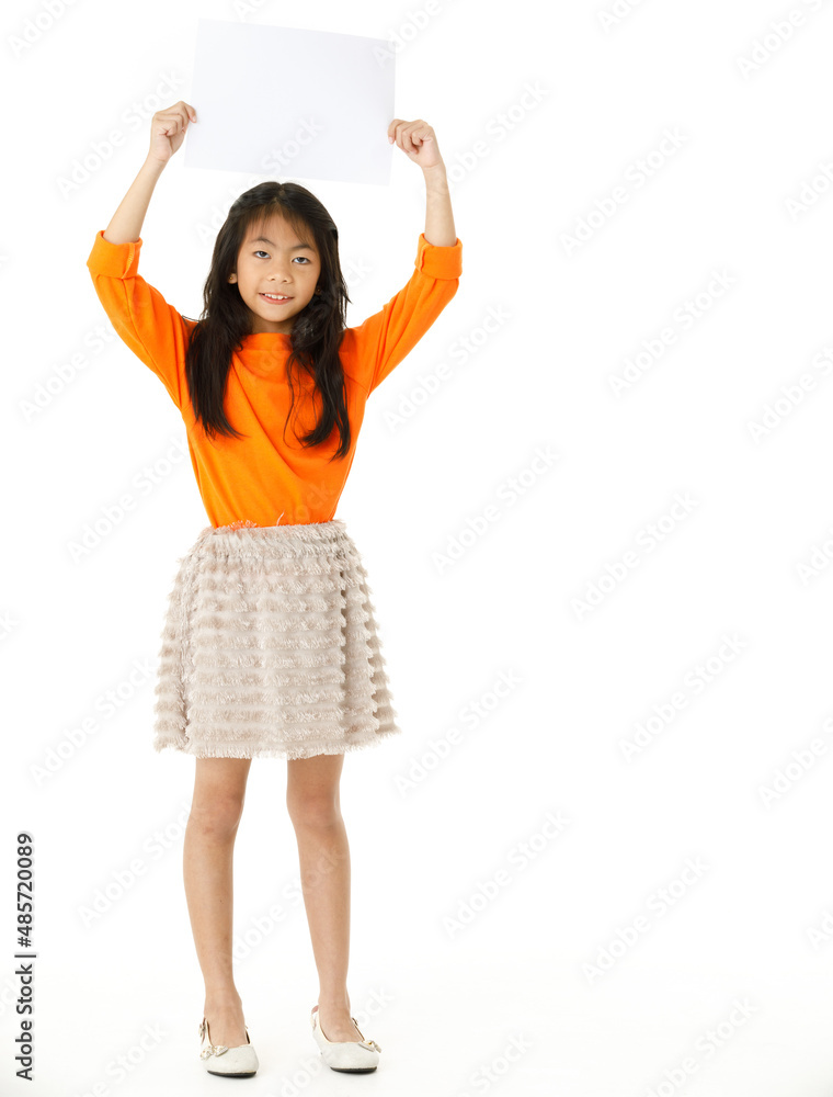 Portrait full body cutout isolated studio shot of Asian young happy primary schoolgirl model in casual outfit standing holding advertising placard paper board for text copy space on white background Portrait full body cutout isolated studio shot of Asian young happy primary schoolgirl model in casual outfit standing holding advertising placard paper board for text copy space on white background