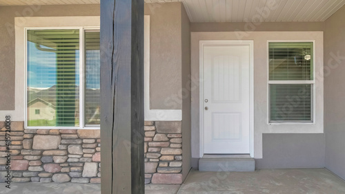 Panorama Front door exterior of a house with gray and white color palette © Jason