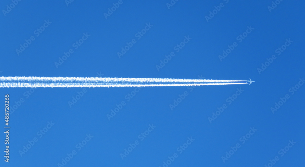 The view of the airplane contrails in the blue sky.