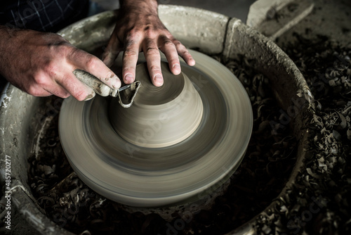 Throwing a pot on a pottery wheel at a Marginea Black Pottery and Ceramics workshop, Bukovina, Romania photo