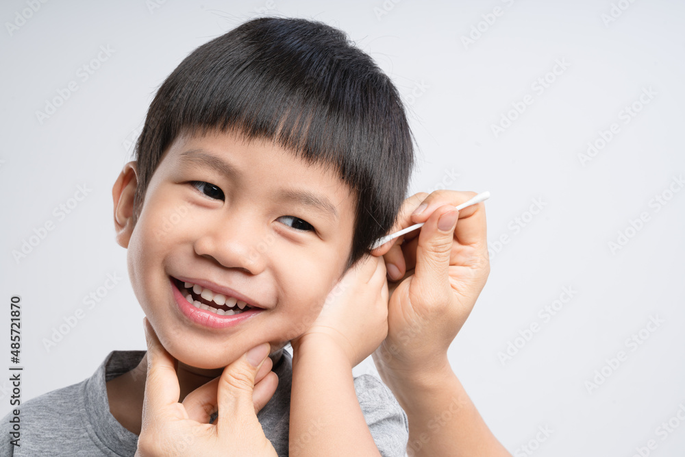 Asian mother cleaning her 4 years old boy ear with cotton swab Asian mother cleaning her 4 years old boy ear with cotton swab