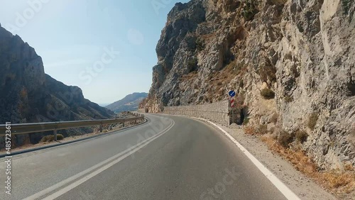 POV car riding through mountain national road in autumn. Auto driving at sunny countryside route. Scenic landscape route at the beautiful season. Concept of traveling.