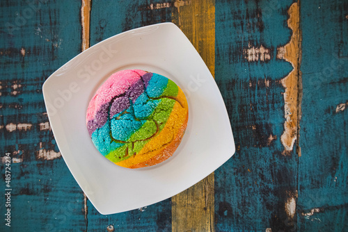 Colorful Rainbow Concha Mexican Pastry on a white plate. A sweet bread with a Heart Shape for LGBT Valentines - a symbol of queer love. photo