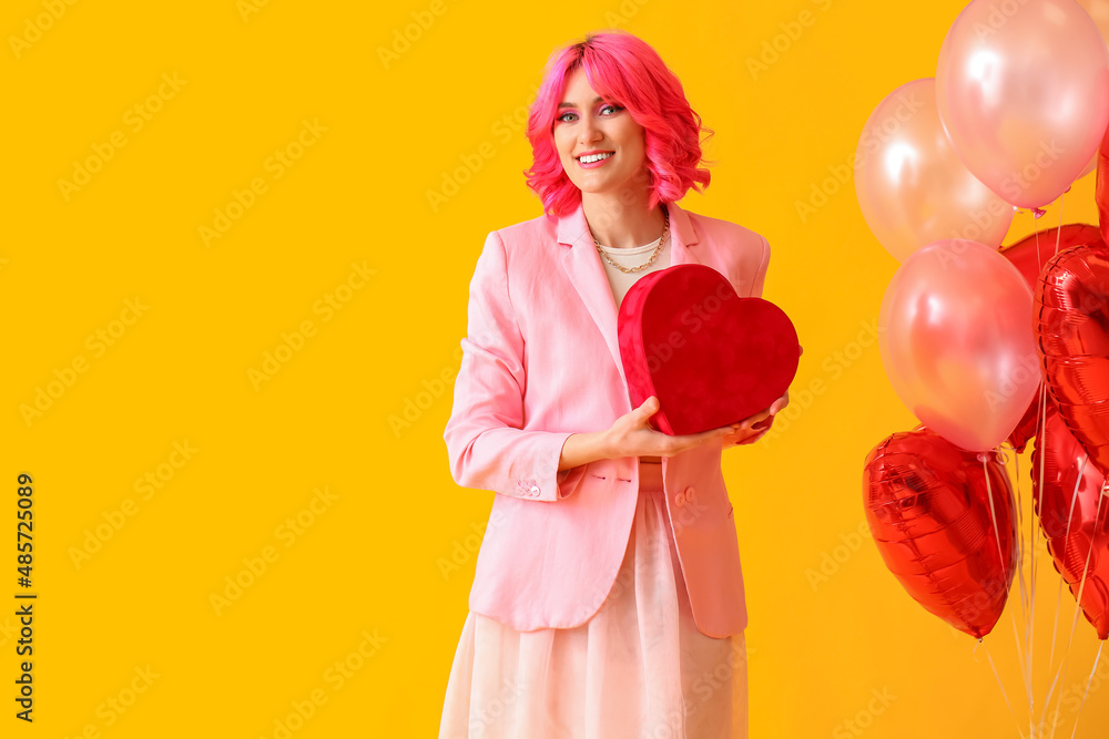 Stylish woman with bright hair, gift and air balloons on color background. Valentine's Day celebration