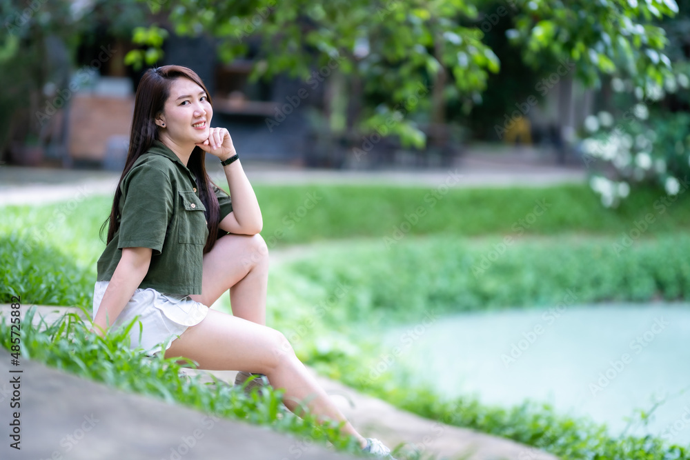 a portrait of beautiful happy asian woman traveler wearing brownish green dress stylish hipster Summer sunny lifestyle on the street outdoors at sunny summer day in park background a portrait of beautiful happy asian woman traveler wearing brownish green dress stylish hipster Summer sunny lifestyle on the street outdoors at sunny summer day in park background