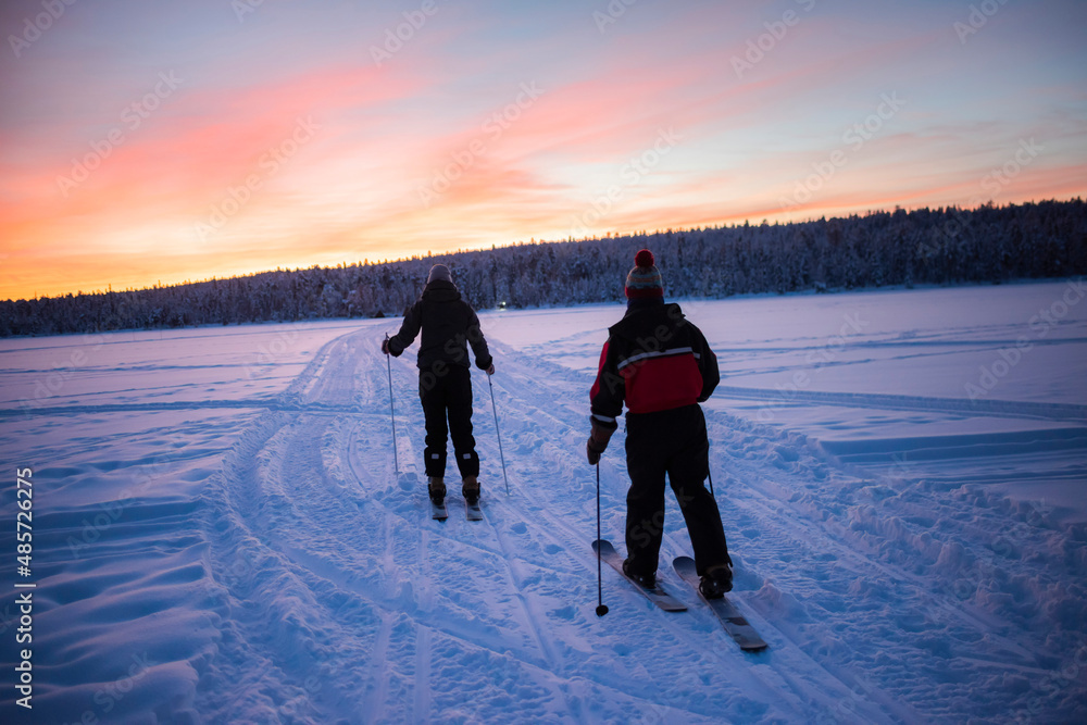Skiing on the frozen lake at Torassieppi at sunset, Lapland, Finland