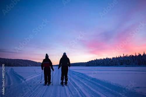 Skiing on the frozen lake at Torassieppi at sunset, Lapland, Finland