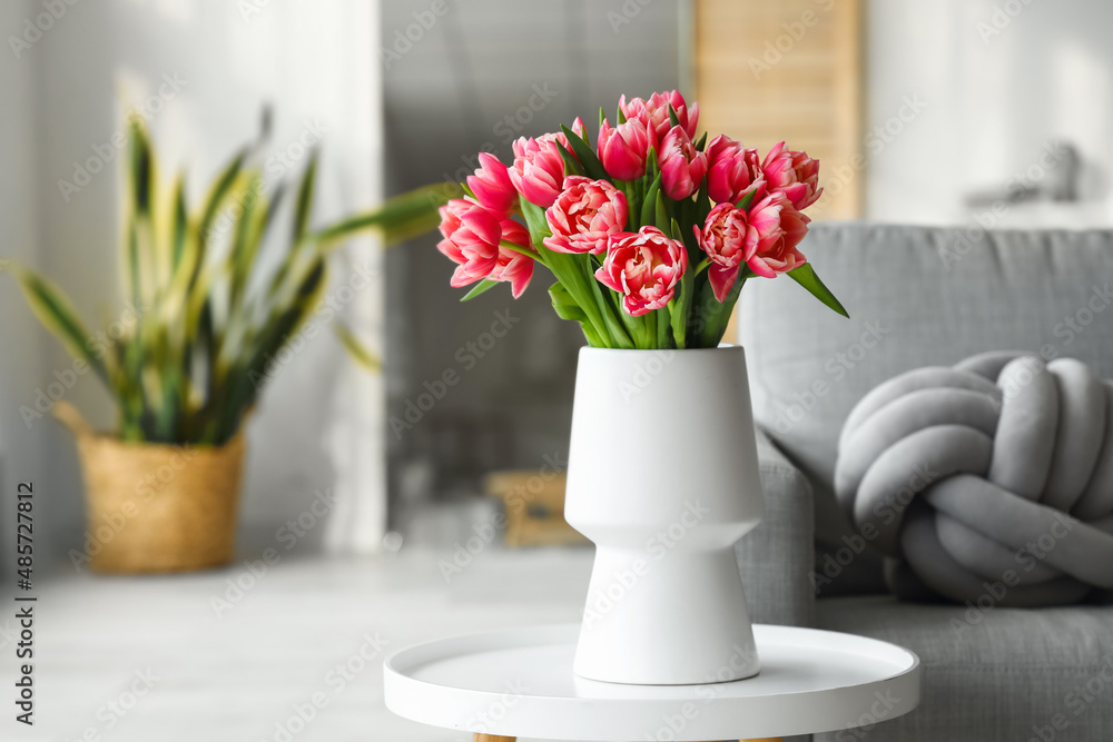 Vase with tulip flowers on small table in living room Vase with tulip flowers on small table in living room