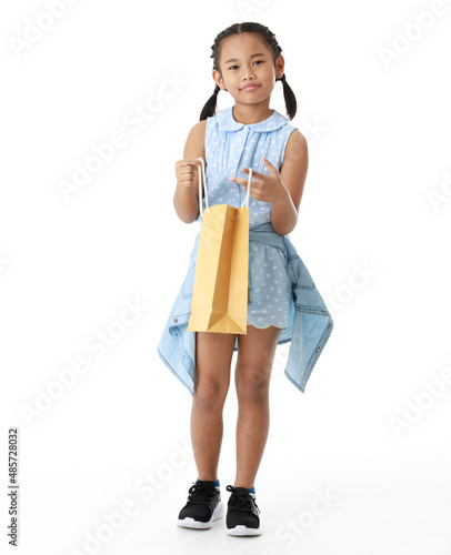 Portrait full body studio cutout shot Asian young pigtail braid hair shopper girl in blue dress standing smiling holding paper shopping bag look at camera on white background