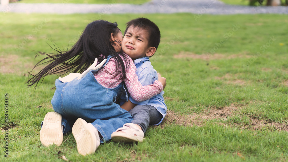 Asian sister is hugging and soothing crying little brother to make him feel better, concept of sibling kid, love, relation, friendship and growth of children in family life. Asian sister is hugging and soothing crying little brother to make him feel better, concept of sibling kid, love, relation, friendship and growth of children in family life.