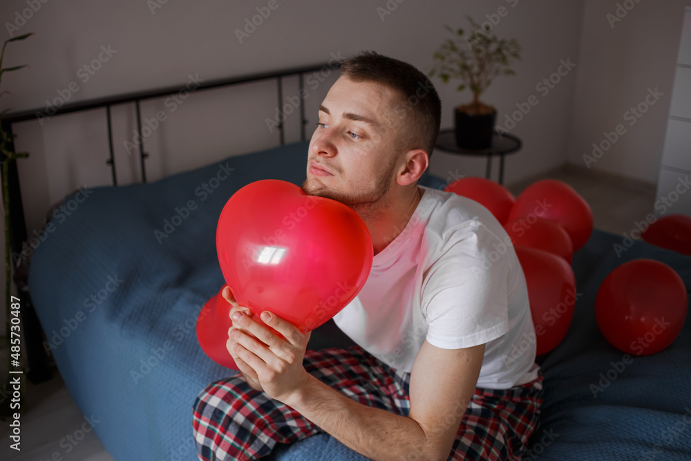 The guy holds a balloon in the form of a heart, for Valentine's Day The guy holds a balloon in the form of a heart, for Valentine's Day