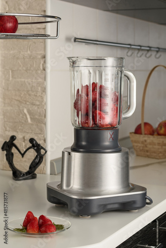 Blender filled with strawberries for making smoothies