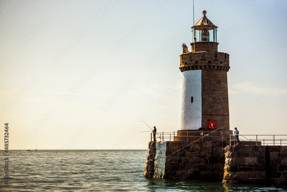 Fishing from the lighthouse in St Peter Port Harbour, Guernsey, Channel Islands, United Kingdom Fishing from the lighthouse in St Peter Port Harbour, Guernsey, Channel Islands, United Kingdom