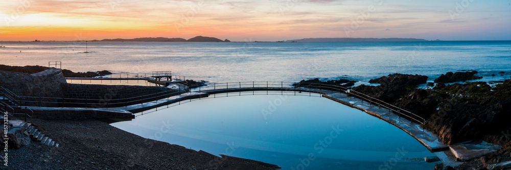Guernsey Bathing Pools at sunrise with Herm Island behind, Channel Islands, United Kingdom