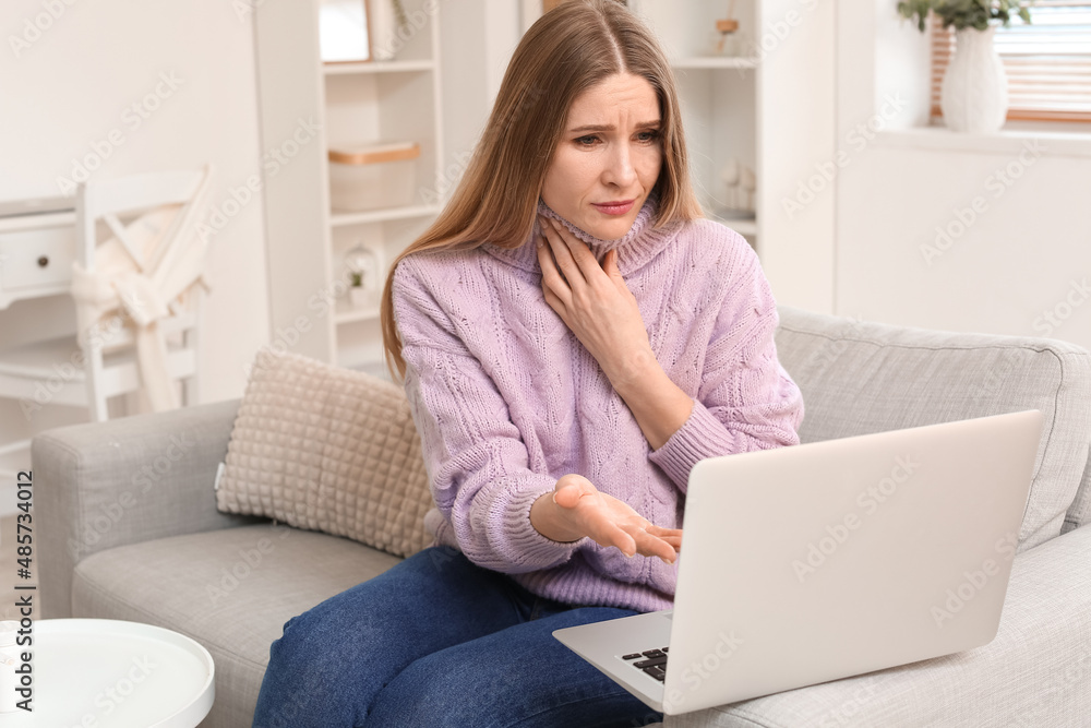 Beautiful woman suffering from sore throat and video chatting with doctor at home Beautiful woman suffering from sore throat and video chatting with doctor at home